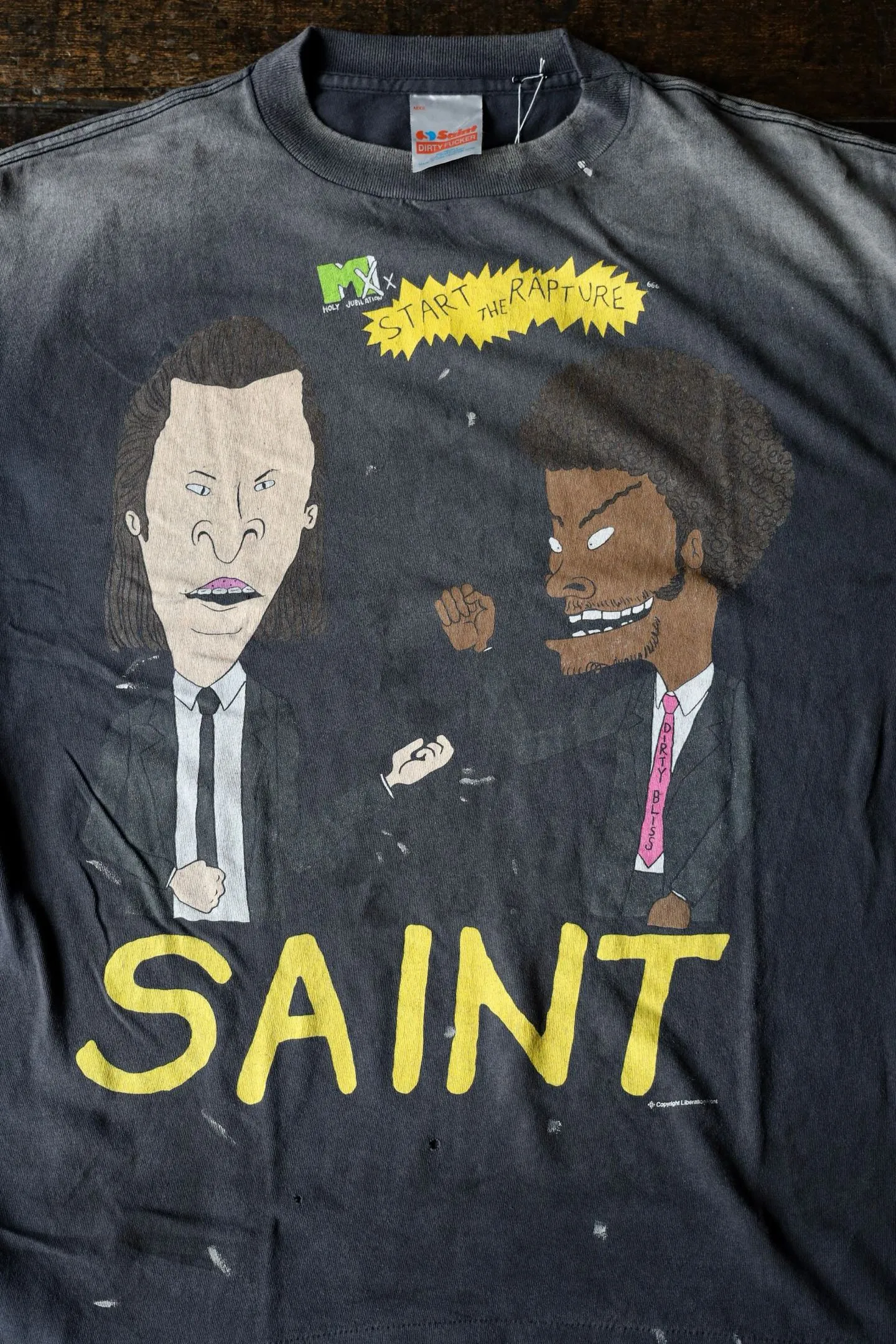 SAINT Mxxxxxx RAPTURE SS TEE/BLK Beavis and Butt-Head anime character TEE. Washed black S-XL. The print is from the characters of the American classic animation "Beavis and Butt-Head". It also pays tribute to the two classic killer characters in "Pulp Fiction". It is very witty and humorous. The whole garment is washed again.